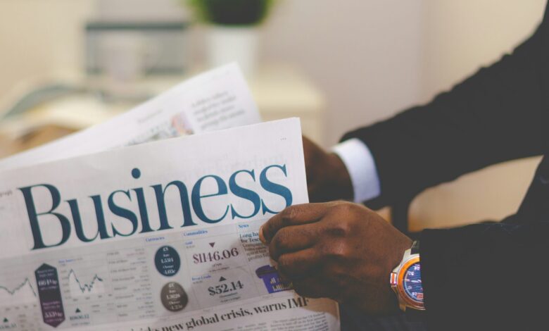 person wearing suit reading business newspaper